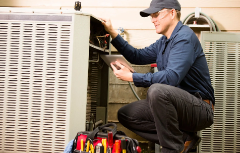 technician inspecting an air conditioning unit.