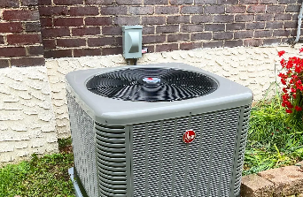 A grey Rheem HVAC unit sits outside,