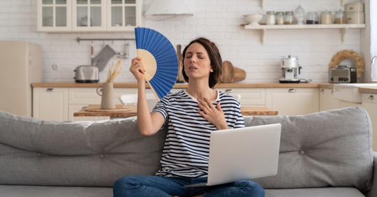 woman fanning herself in home