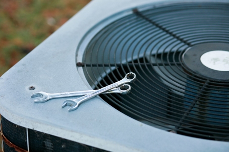 air conditioner unit with two wrenches on top