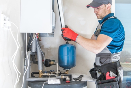A technician repairs a home furnace.