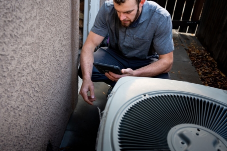 technician inspecting an AC